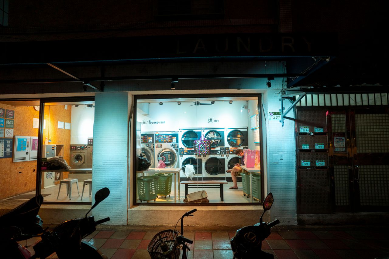 A cozy urban laundromat at night with a welcoming interior and modern washing machines.